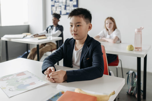 enfant TDAH concentre grace a un coussin a picots sur sa chaise de bureau a la maison