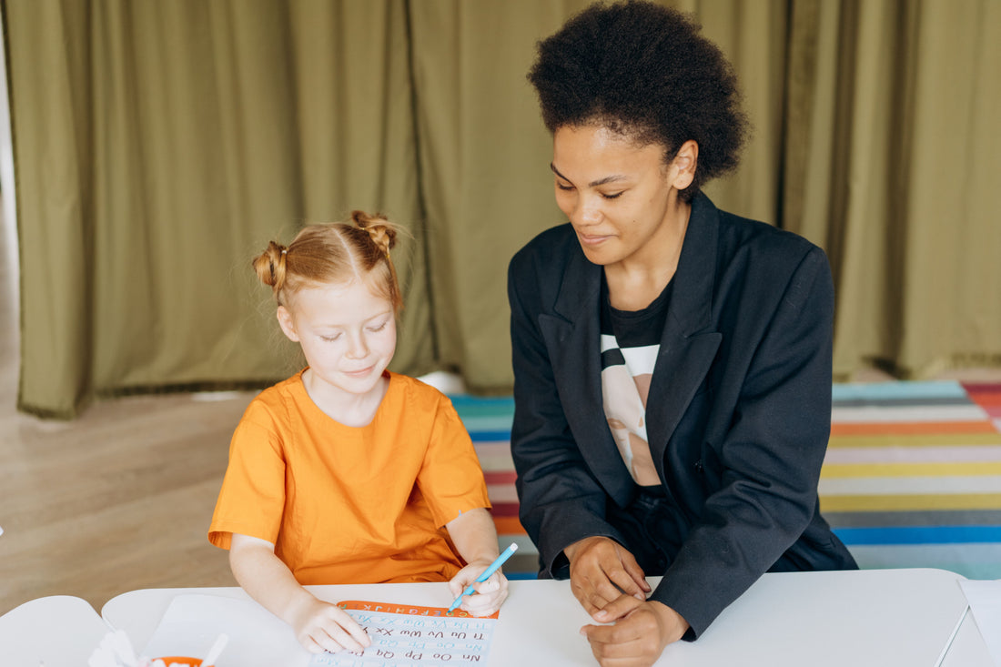 AESH utilisant du matériel pédagogique adapté avec un élève DYS ou TDAH en classe primaire